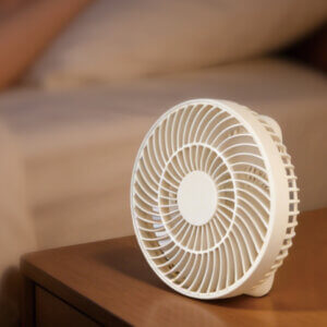 Foldable Handheld and Desktop Mini Fan, showing its stable folded desktop form and spiral front grille details.