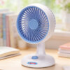 Automatic Oscillating Desktop Quiet Mini Fan, showing its white and blue two-tone appearance, spiral grille, and blue knob switch on the base.