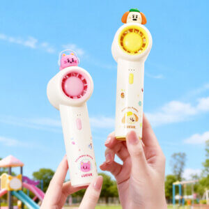 Cute Cartoon Figurine Handheld Mini Fan, showing its top 3D animal figurines, circular fan head, and printed handles in pink and yellow accents.