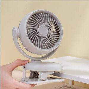 Automatic Oscillating Clip-on Desktop Mini Fan, showing its mint green appearance, spiral air guide grille, tilt-adjustable U-bracket, and clamp base with control button.