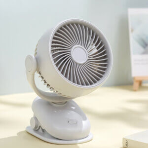 Automatic Oscillating Clip-on Desktop Mini Fan, showing its mint green appearance, spiral air guide grille, tilt-adjustable U-bracket, and clamp base with control button.