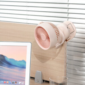 Automatic Oscillating Clip-on Desktop Mini Fan, showing its mint green appearance, spiral air guide grille, tilt-adjustable U-bracket, and clamp base with control button.