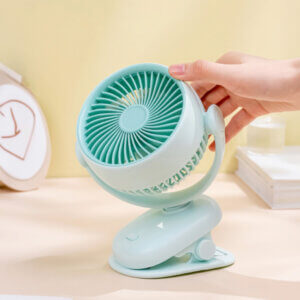 Automatic Oscillating Clip-on Desktop Mini Fan, showing its mint green appearance, spiral air guide grille, tilt-adjustable U-bracket, and clamp base with control button.