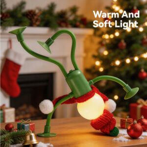 Christmas Creative Suction Cup Figurine Flexible Mini Night Light, showing its spherical glowing bulb head, red knitted beanie hat, mini scarf, bendable limbs, and suction cup hands and feet, available in red and green colorways.